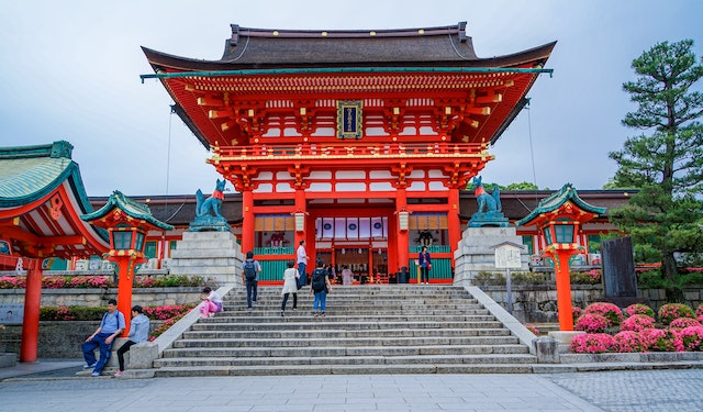 an ancient red temple at the top of a flight of stone steps